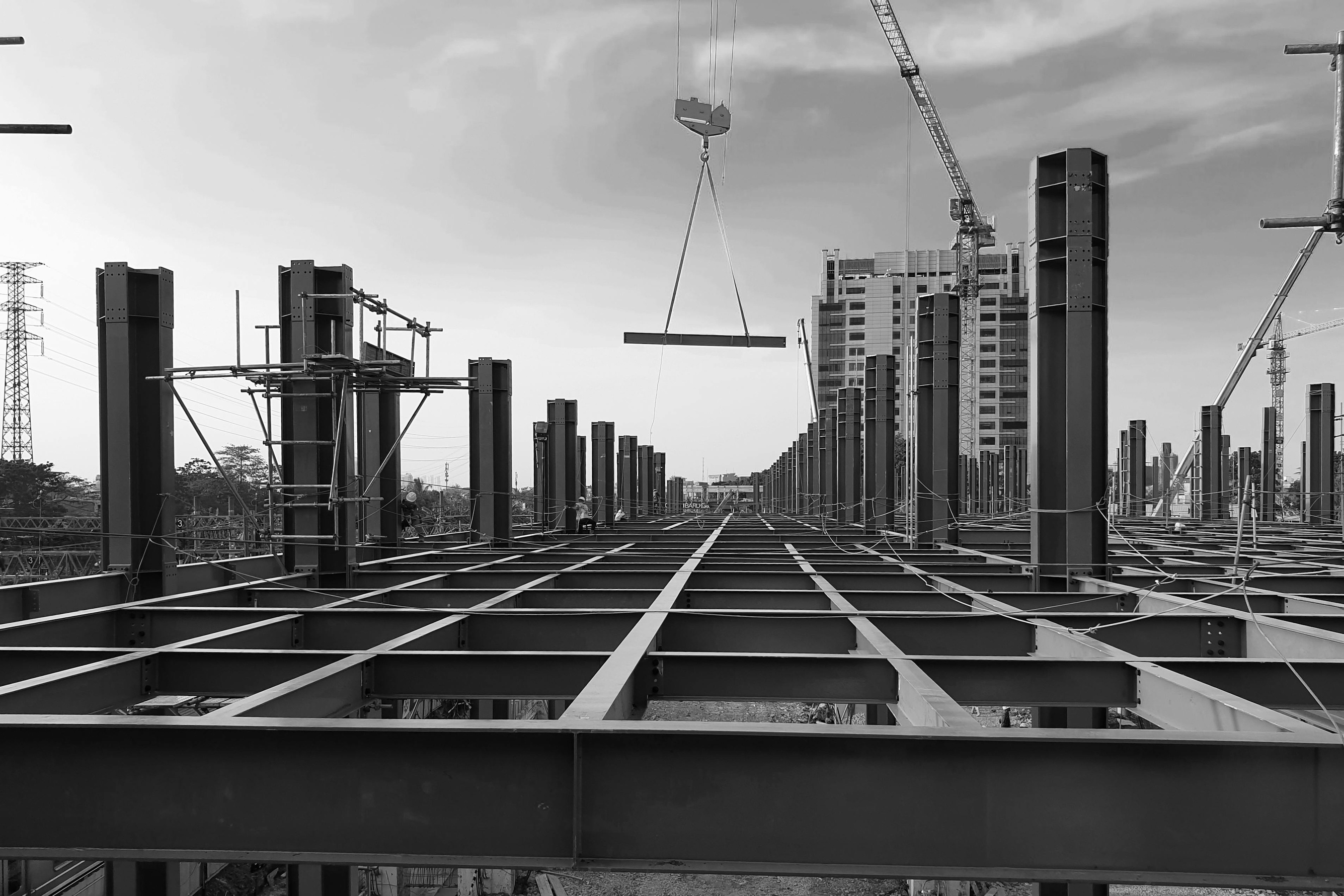 Staalconstructie met kraan die een ligger hijst